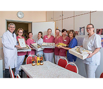 Prof. Dr. med. Gernot Geginat, Leiter des Bereichs Krankenhaushygiene des Instituts für Medizinische Mikrobiologie und Krankenhaushygiene, übergibt als kleine Anerkennung ein Stationsfrühstück an die neonatologische Intensivstation für die durchgehend vorbildliche Umsetzung wichtiger Maßnahmen im Bereich Händehygiene